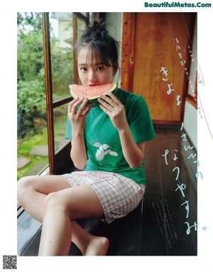 A young girl laying on the floor in a green shirt.