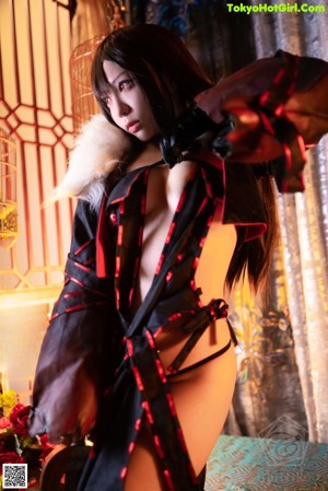 A woman in a black and red outfit holding a sword.