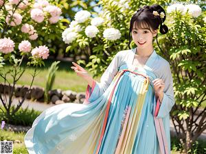 A woman in a pink and blue dress standing in a garden.