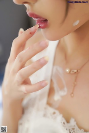 A woman in a white lingerie leaning against a wall.