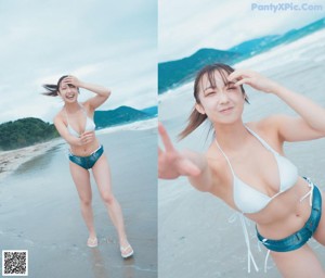 A woman crouching down on the beach with a blue umbrella.