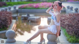 A woman in a pink and white outfit is posing for a picture.