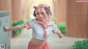 A woman with pink hair standing in front of a train.