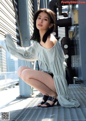 A woman in a black dress standing on a set of stairs.