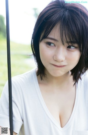 A woman sitting on a swing in a park.