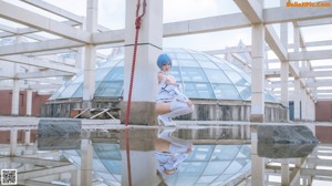 A woman with blue hair sitting on a metal structure.