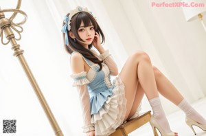 A girl in a blue and white dress posing for a picture.