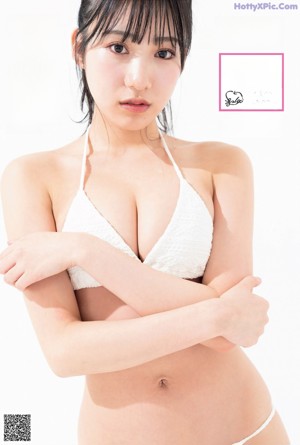 A woman in a white bikini posing for a picture.
