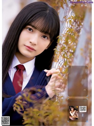 A young woman in a school uniform posing for a picture.