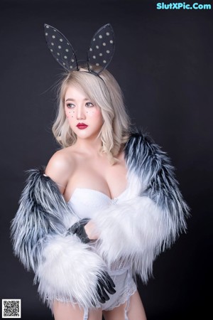 A woman in a fur coat and bunny ears posing for a picture.