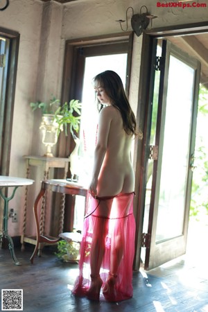 A woman in a pink dress standing in a room.