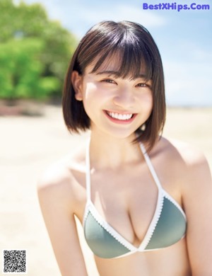 A woman in a blue and white one piece swimsuit standing next to a pool.