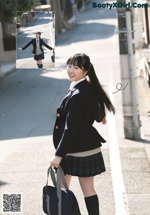 A woman in a school uniform holding a water bottle.