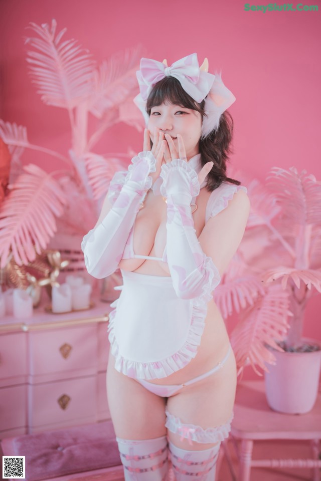 A woman in a pink and white lingerie posing for a picture.