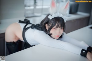 A couple of women in bunny costumes kissing each other.