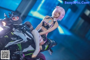 A woman in a bikini sitting on a motorcycle holding a flag.