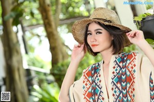 A woman wearing a straw hat and a colorful kimono.