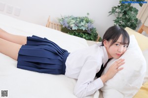 A young woman in a school uniform posing for a picture.