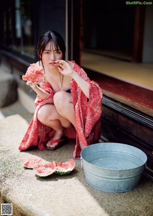 A woman in a white robe standing in the grass.