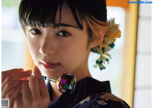 A woman in a blue kimono with a flower in her hair.