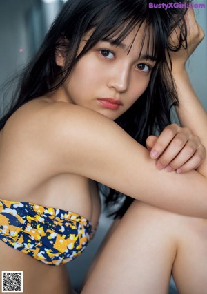 A woman with long black hair is posing for a picture.