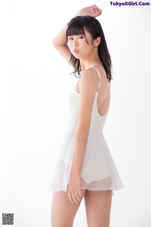 A woman in a white dress posing for a picture.