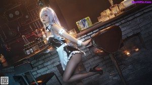 A woman dressed as a bunny sitting on a bar stool.